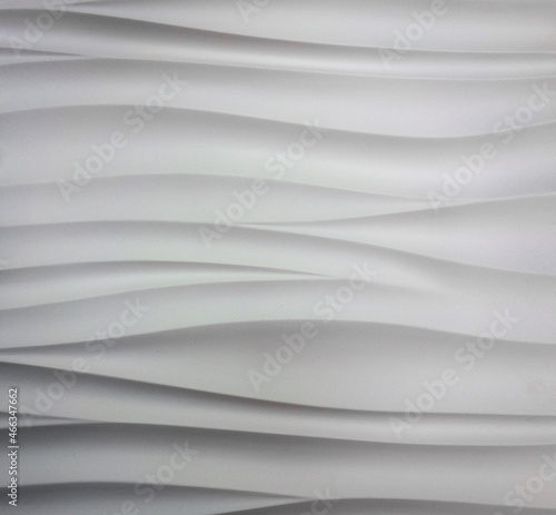 Photo of a beige texture with horizontal wavy lines. Plastic construction tile of square shape for interior walls and ceiling.