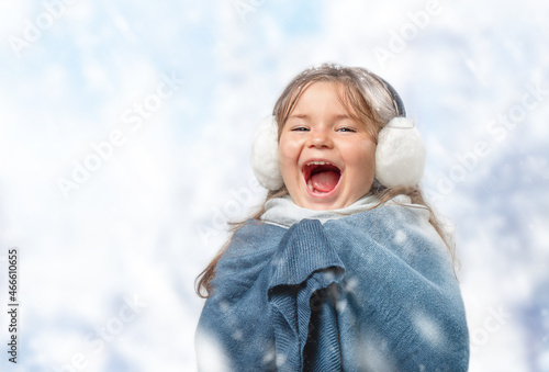 Child girl in earmuff screaming with joy