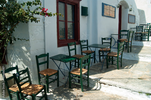Beautiful Amorgos island, Greece. Traditional taverna with shaded terrace. Old fashioned tables and chairs. Landscape aspect shot.