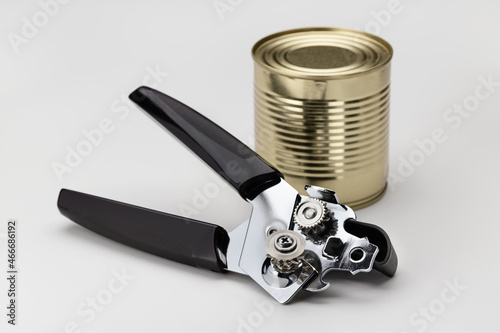  Food can and modern airtight can opener. Closeup, white background.