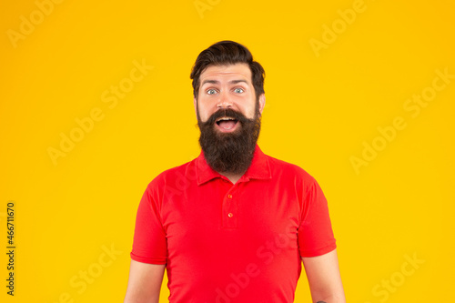 amazed bearded man with moustache in tshirt on yellow background, portrait