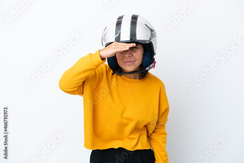 Woman with a motorcycle helmet looking far away with hand to look something