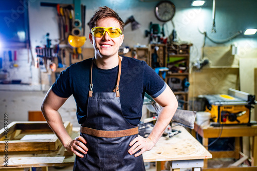 Young carpenter sawing board with circular saw