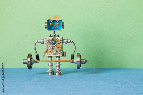 A toy robot weightlifter lifts a heavy steel barbell. strength weight training exercise. Sport fitness, weightlifting and power lifting athletics workouts