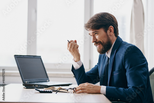 man in a suit in the office in front of a laptop executive success