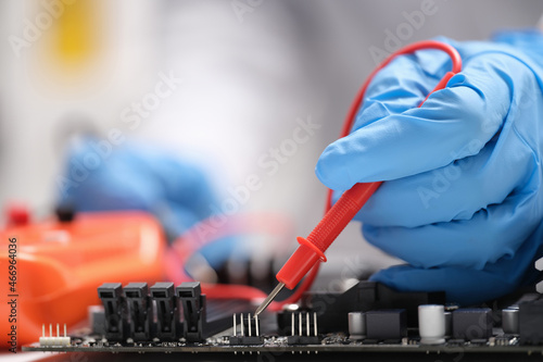 Master repairer testing motherboard with feeler gauge closeup