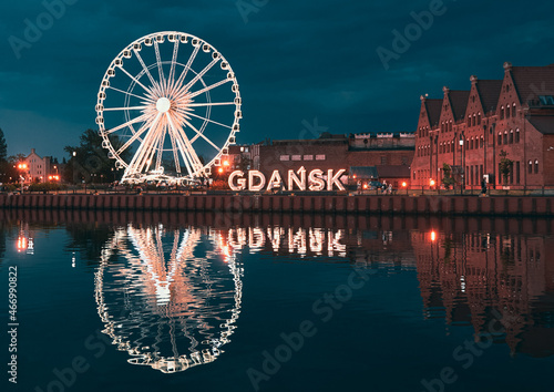 Reflection of the Ferris wheel in Gdansk, Poland. Old town center in the touristic city on the shore of the Baltic Sea in Poland. Beautiful night city lights