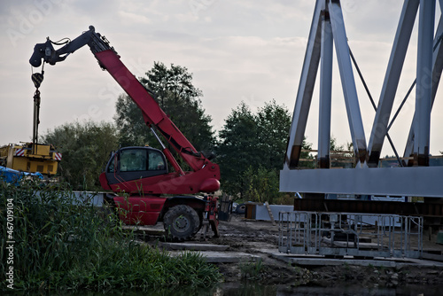 Budowa mostu . Czerwona koparka , dźwig i most. Building a bridge.. Red excavator, crane and bridge 