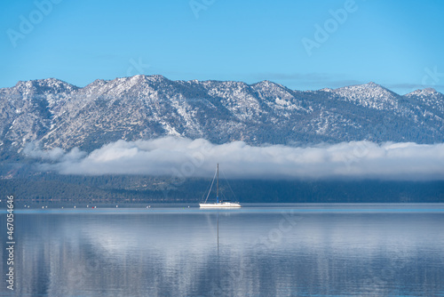 White Sailboat on Lake Tahoe with Snow Covered Sierras and a Long Cloud in November, Off Season