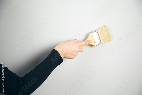 woman painting a wall with a brush
