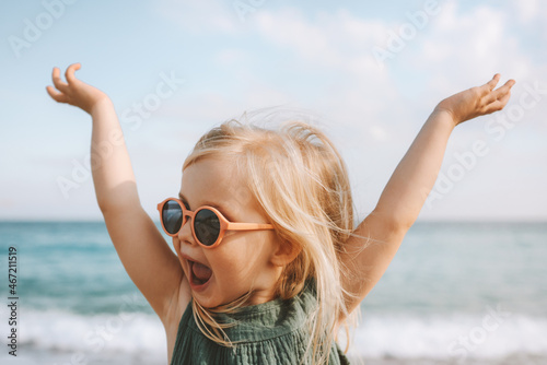 Child playing outdoor emotional surprised emotional funny girl in sunglasses 3 years old toddler raised hands family vacations outdoor