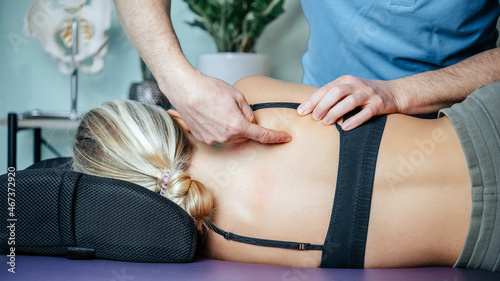 Osteopath pointing at rhomboid muscle before performing myofascial release technichue