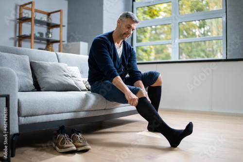 Man Putting On Medical Compression Stockings