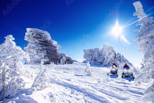 Polar arctic snow mountains with sun light. Concept travel tourist group snowmobile tour in frozen forest