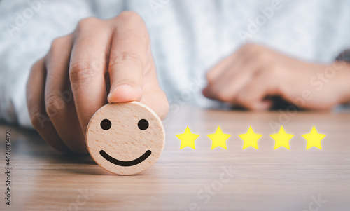 Business woman hand holding smiley face emoticon on virtual touch screen.good feedback rating and positive customer review, experience, satisfaction survey, world mental health day concept