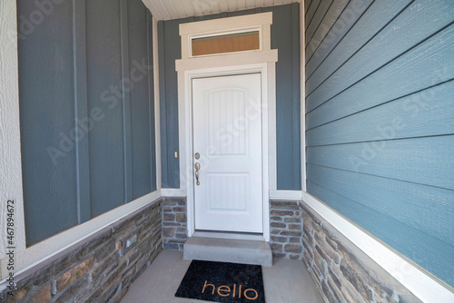 Front door exterior of a house with wooden wall siding and stone bricks