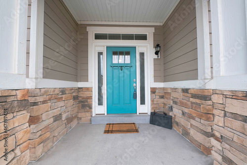 Turquiose front door with two side panels and white doorframe