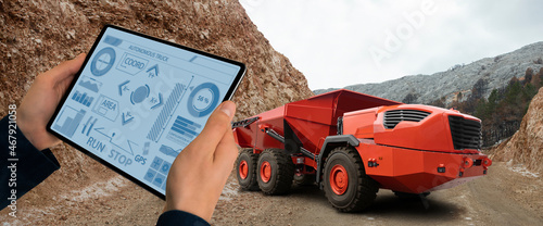 Man controls autonomous mining truck using digital tablet