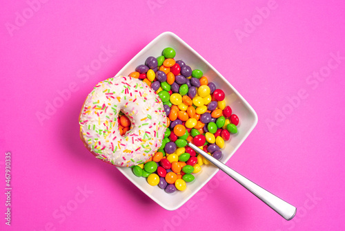 Donut with bowl full of colorful sweets. 