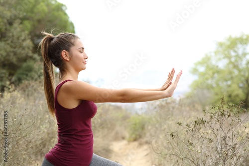Teenager practicing tai chi exercises in the mountain