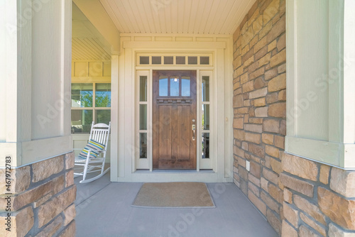 Dark wooden front door with transom window and side panels
