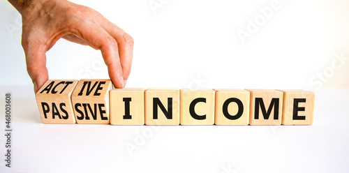 Passive or active income symbol. Businessman turns wooden cubes and changes words passive income to active income. Beautiful white background, copy space. Business, passive or active income concept.