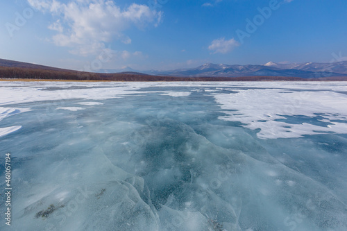 Beautiful ice of a frozen lake. Overall plan. Sikhote-Alin Biosphere Reserve in the Primorsky Territory.