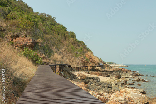 Rocks on the beach are rocks and brown wooden bridges along the hillsides, rocky mountains and sea close to island, eco-tourism concept