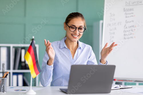E-learning with teacher, social distancing. Happy female tutor giving German language lesson online on laptop