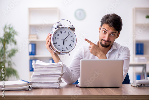 Young male employee in time management concept