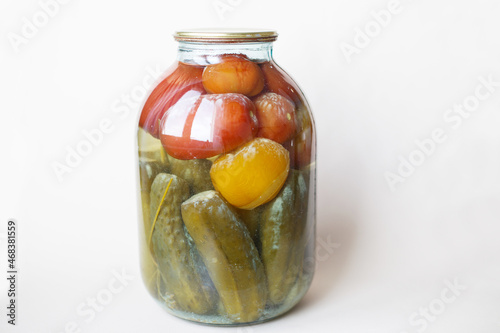 spoiled can of vegetable seaming. Glass jar with homemade pickled tomatos and cucumbers with white fungus