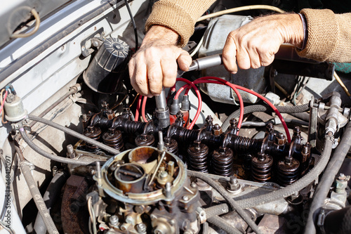 the mechanic uses a torque wrench to repair gas distribution mechanism at old engine. Disassembled carburetor motor. DIY repair. cylinder head with camshaft