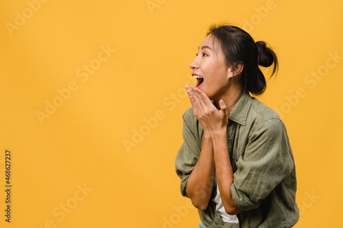 Young Asia lady feel happiness with positive expression, joyful surprise funky, dressed in casual cloth isolated on yellow background. Happy adorable glad woman rejoices success. Facial expression.