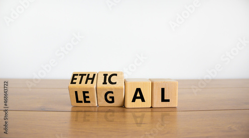 Ethical or legal symbol. Turned wooden cubes and changed the word 'legal' to 'ethical' on a beautiful wooden table, white background. Business and ethical or legal concept. Copy space.