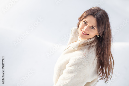 Portrait of a beautiful European woman in a winter forest, the woman has long hair, celebrating Christmas and New Year. 