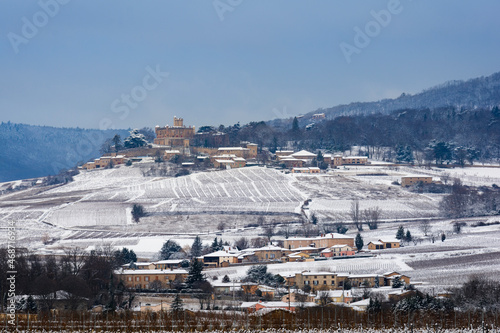 Snowed landscape of Beaujolais with vineyards and Montmelas castle, France