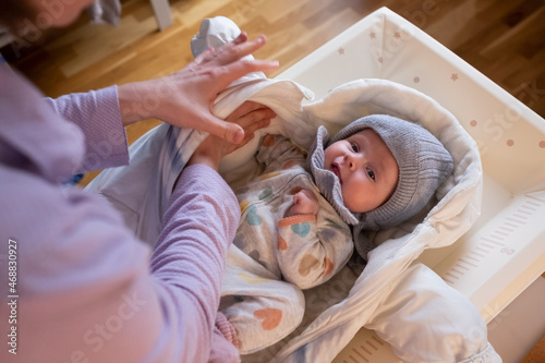 putting on warm clothes on baby girl preparing for a walk on cold winter day.