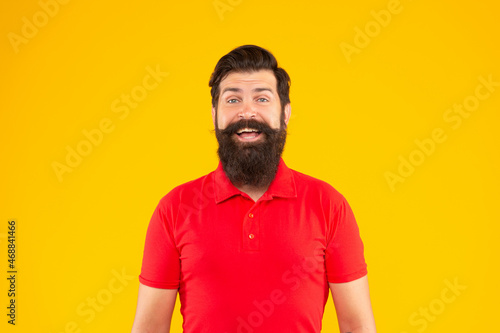 happy hipster male with beard on yellow background, face