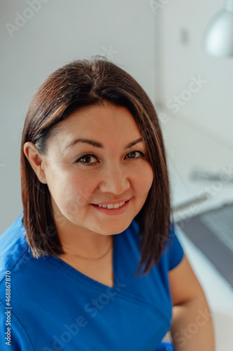 portrait of happy female doctor sitting at a table with a laptop in uniform