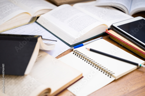 Closeup pencil on the notebook with many opened books on the desk, editing or rewrite the information from many reference book to create a new content