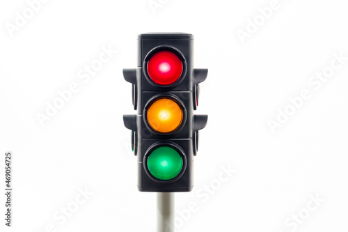 Isolated traffic light showing an illuminated red, amber and, green light. Concept image illustrating control of the COVID pandemic and confusion with movement between levels.