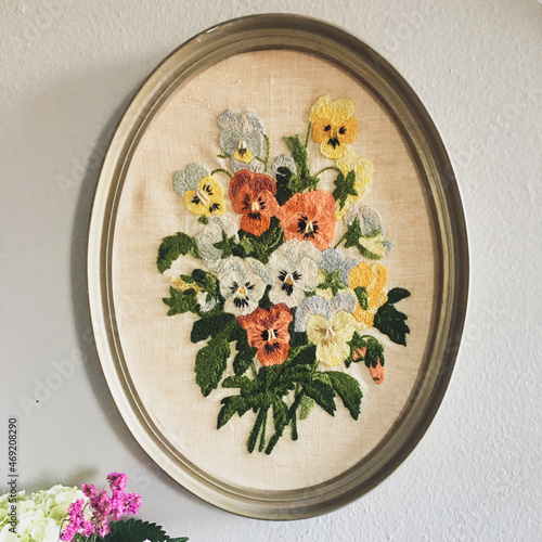 Framed Embroidery on wall with bouquet of flowers