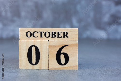 October 6th. Hello October, Cube wooden calendar showing date on 6 October, Wooden calendar with date on a dark background.