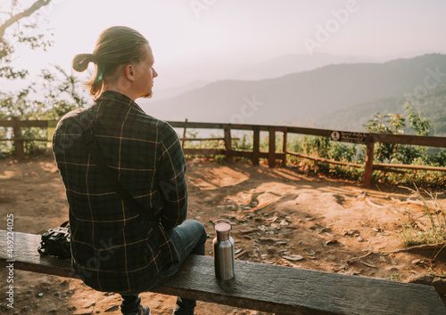 Man is sitting on a bench at viewpoint in the north of Thailand