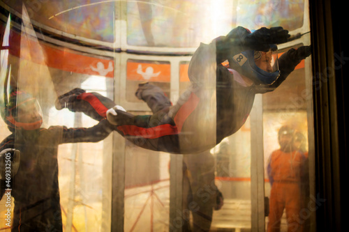 The flight of a young woman in blue helmet in a wind tunnel. Skydiving training.