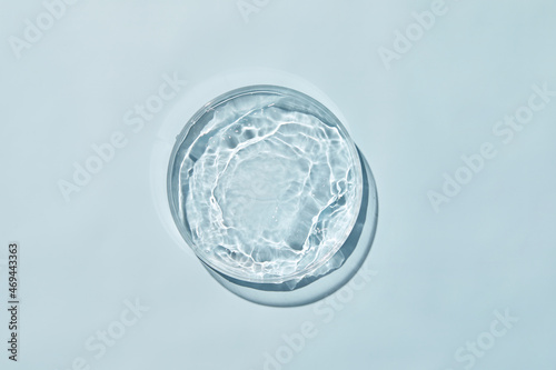 Petri dish with water and ripple in blue background