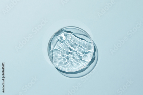 Petri dish with water and ripple in blue background