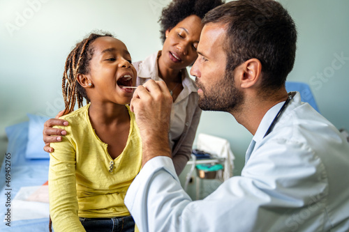 Young male pediatrician doctor examining child at office. Healthcare prevention exam people concept