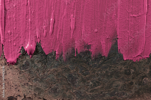 Rozmazana, różowa farba na abstrakcyjnym, surowym tle. Smudged pink paint on an abstract, raw background.
