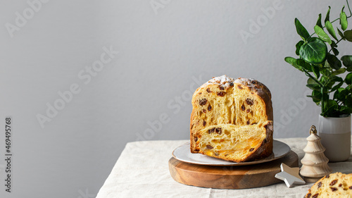 Panettone cake on the table with tableware, Christmas tree ornaments and eucalyptus branch. Nordic style Christmas decoration.Banner